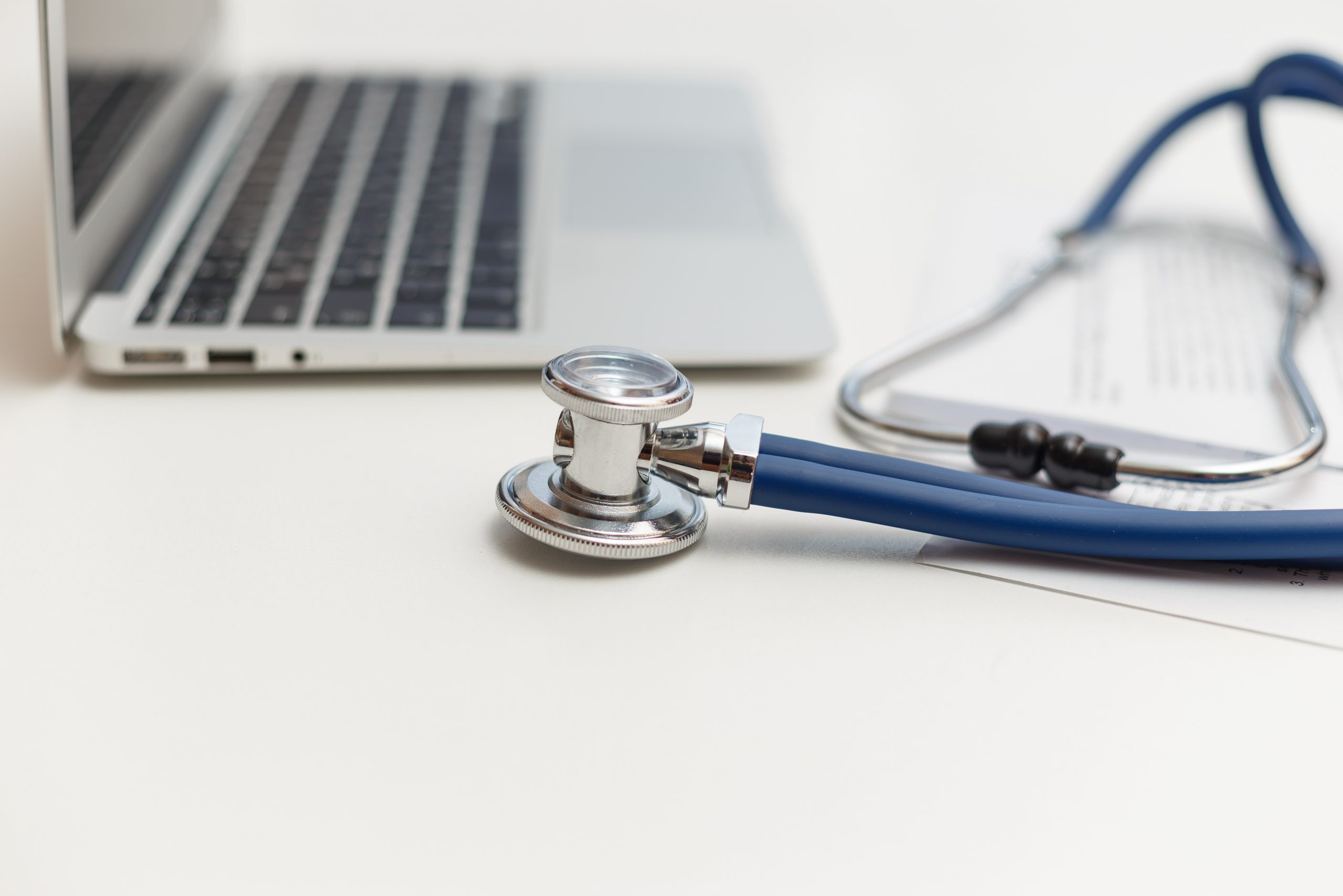 stethoscope and laptop on doctor working desk